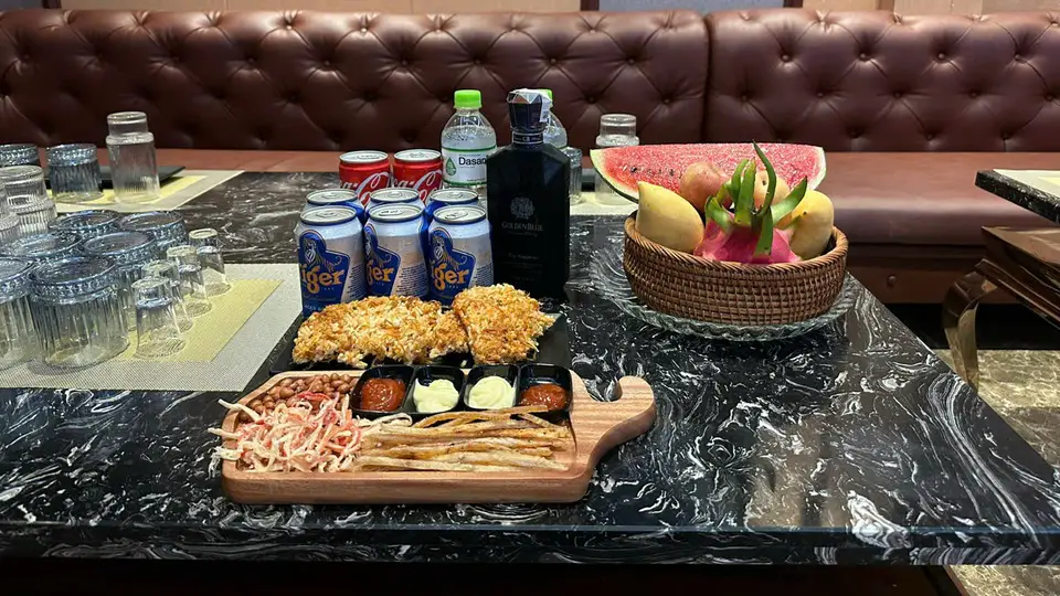 다낭 아우디 가라오케 타이거 맥주, 골든블루 양주, 과일 바구니, 튀김 안주가 대리석 테이블 위에 세팅된 모습