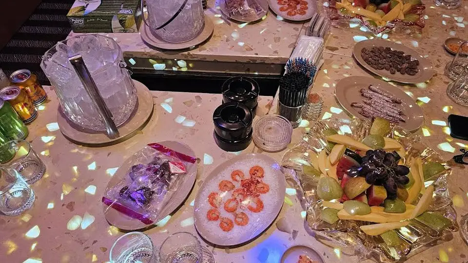 호치민 보스 가라오케 새우, 견과류, 과일 플레이트와 얼음통이 세팅된 보스 가라오케의 테이블 클로즈업