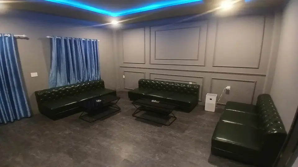 나트랑 나우 스파 블루 간접 조명과 다크 그린 체스터필드 소파 3개가 배치된 넓은 VIP 전용 라운지 룸